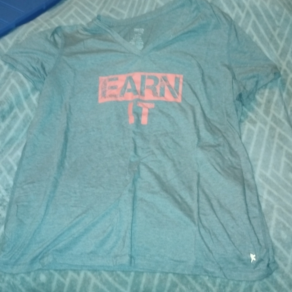 Semi-fitted grey v-neckT-shirt that says "Earn It"